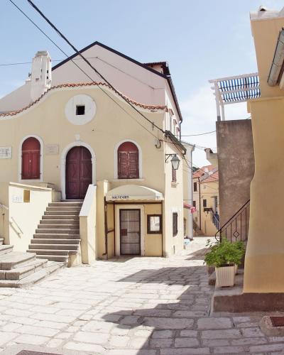 Sunlit alley in Krk, Croatia showcasing charming historic architecture and inviting atmosphere.