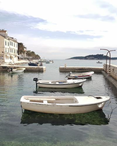 Peaceful harbor scene with docked boats and historic architecture in Hvar, Croatia.