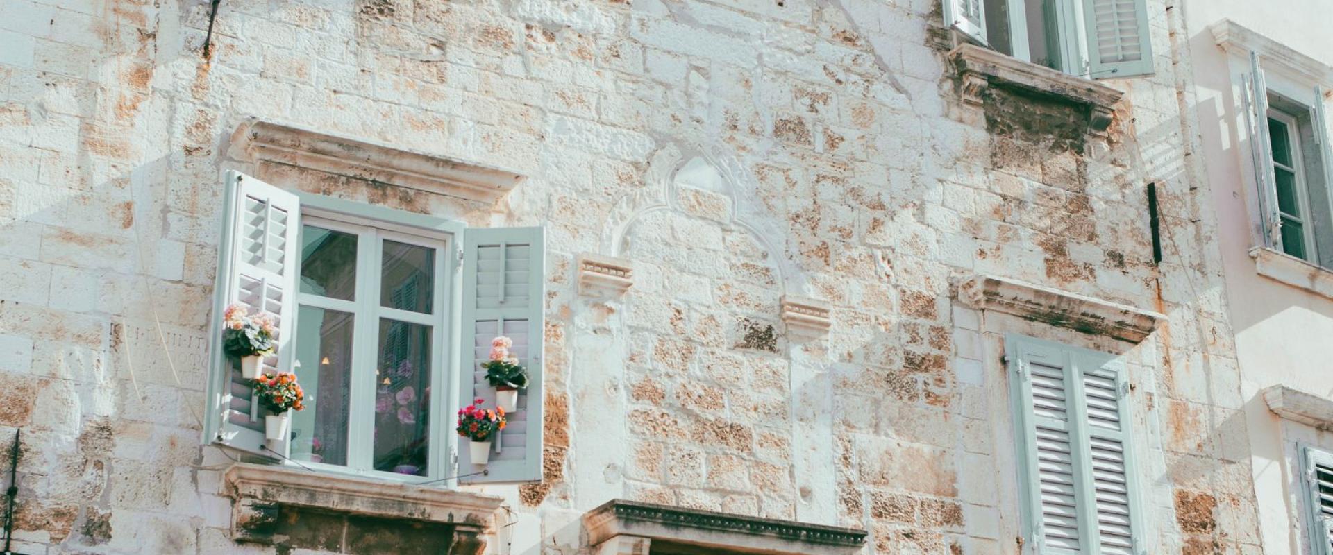 Explore the charming historic architecture of Pula, Croatia with rustic stone buildings and quaint windows.
