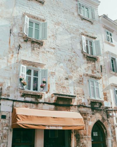 Explore the charming historic architecture of Pula, Croatia with rustic stone buildings and quaint windows.
