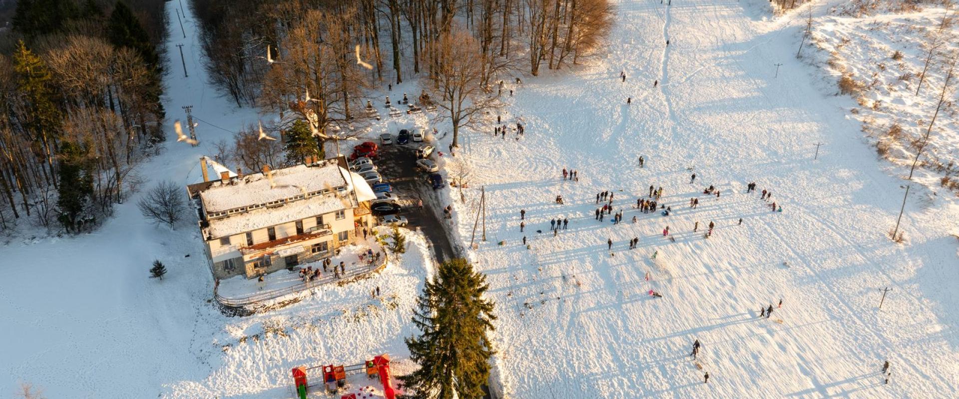 Aerial view of a snowy winter landscape in Daruvar, Croatia, with people enjoying outdoor activities.